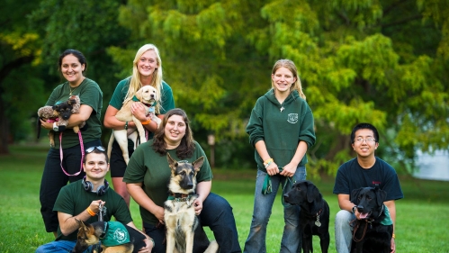 Students from the Seeing--Eye Puppy Club posing with dogs.