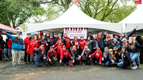 A group of alumni standing in front of a tent at Homecoming.