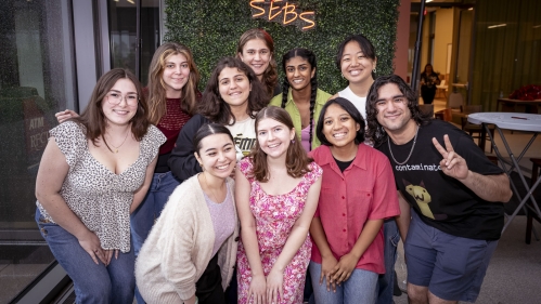 A group of students in front of a 'SEBS' sign.