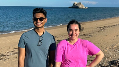 Two grad students standing on a beach.