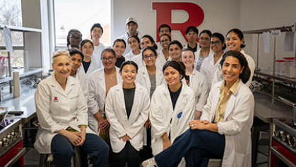 A group of students and instructors wearing lab coats