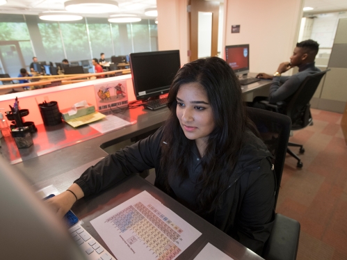 A student working on a computer at a desk.