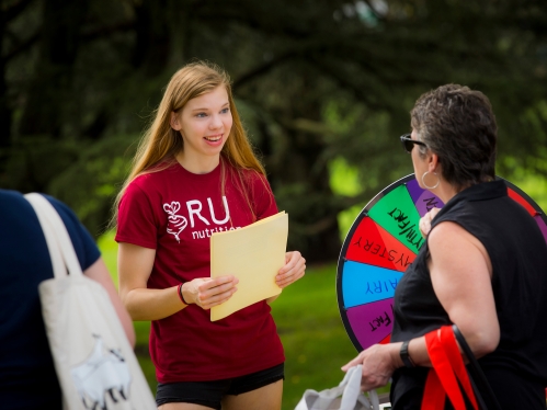 A student handing information to an adult.