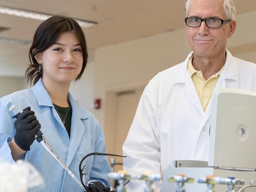 A student and a professor in a lab.