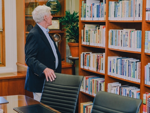 Lester R. Brown looking at shelves of books in the Lester R. Brown Reading Room.