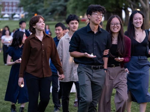 A group of people walking holding candles
