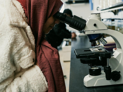 A student looking through a microscope.