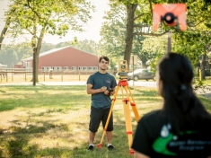 A student taking measurements on Cook campus.